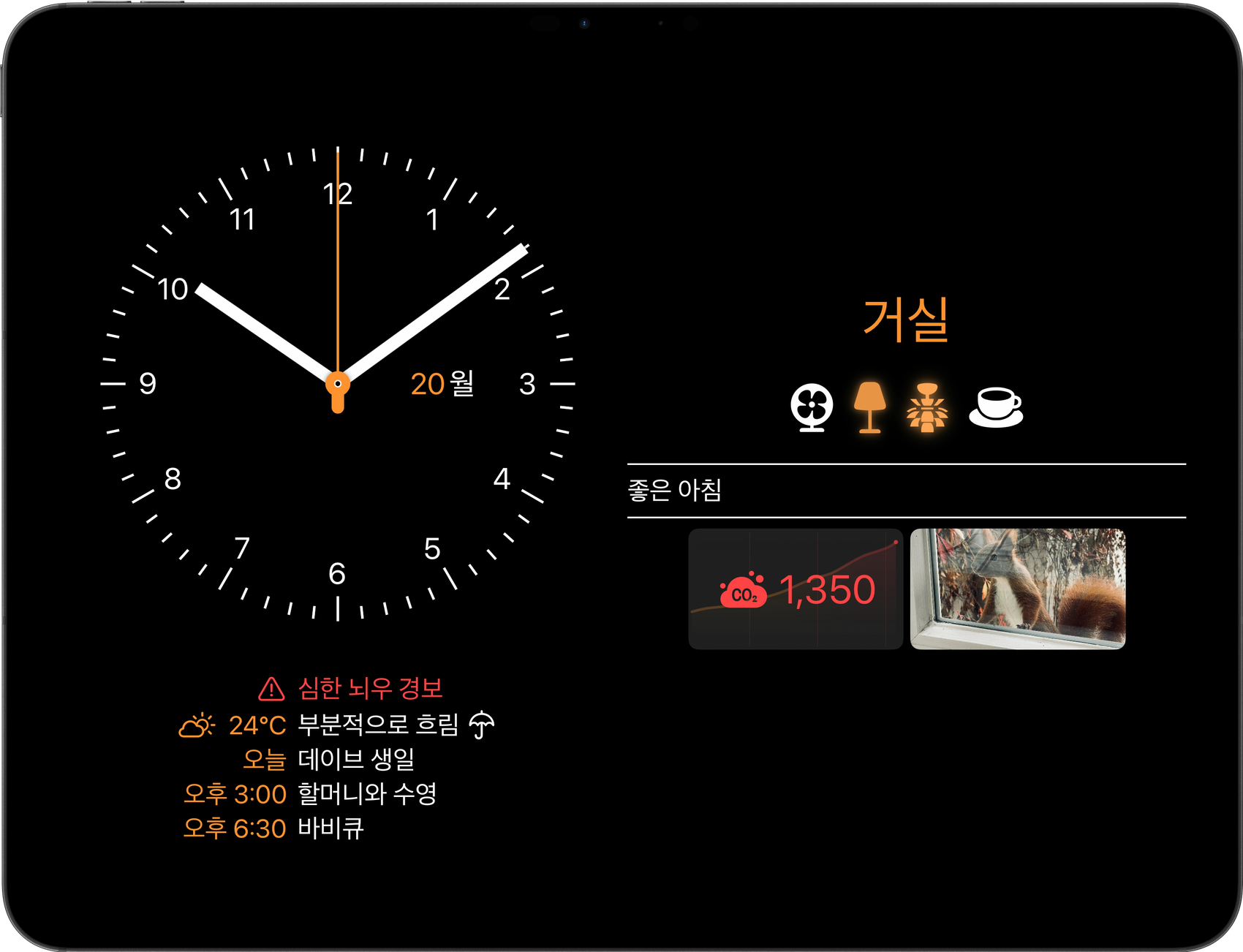 iPad에 표시된 Wallflower 3. 벽시계와 오늘 캘린더 옆에 방 대시보드가 있고 악천후 경보, CO₂ 수치, 카메라가 보임